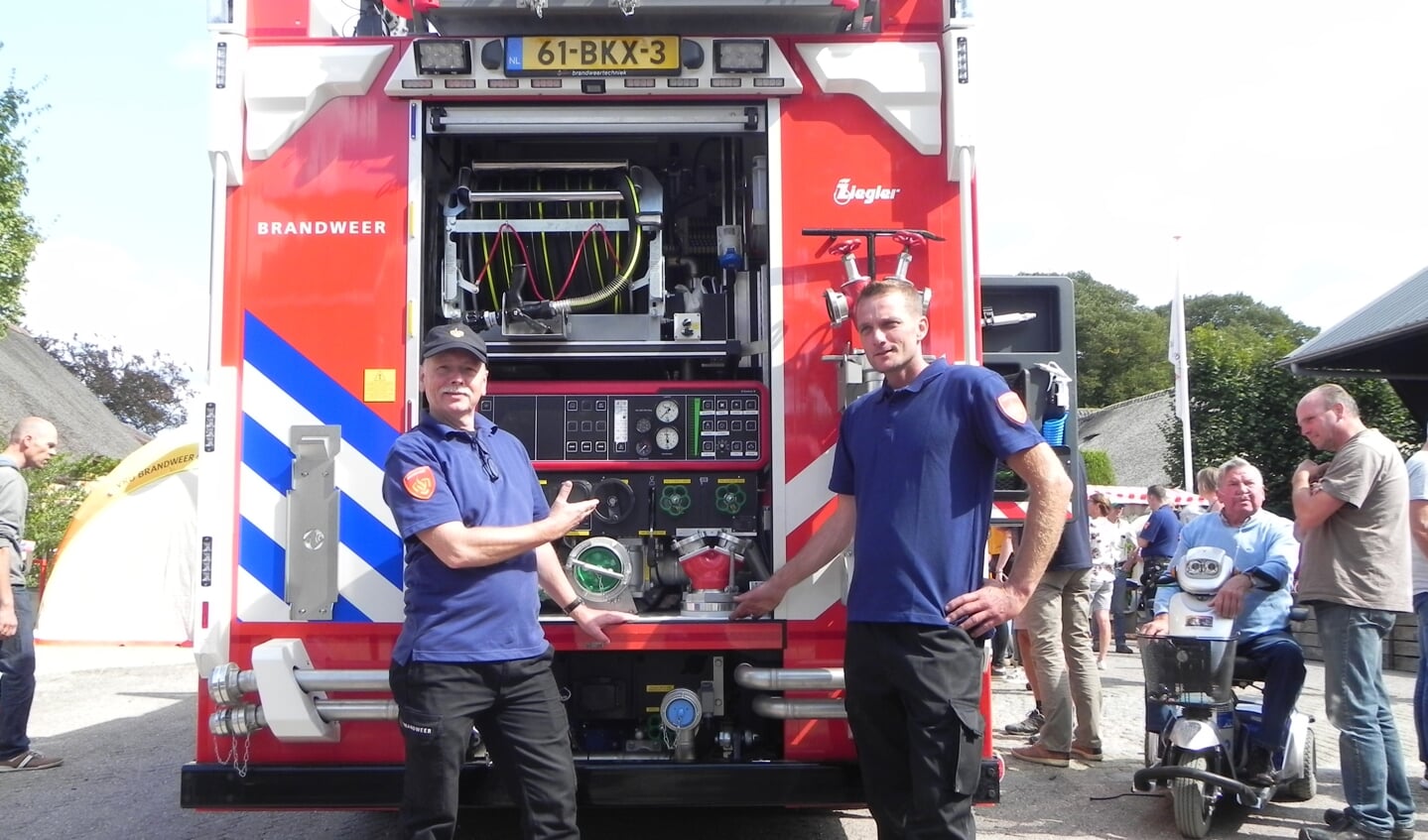 Huidig en opvolgend postcommandant van den Dikkenberg en van Wijk tonen trots hun nieuwe brandweerwagen.   