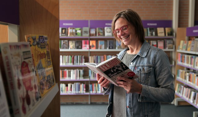 Thalita Boogaard van de bibliotheek snuffelt alvast even in een popgeschiedenisboek van Lex Harding.
