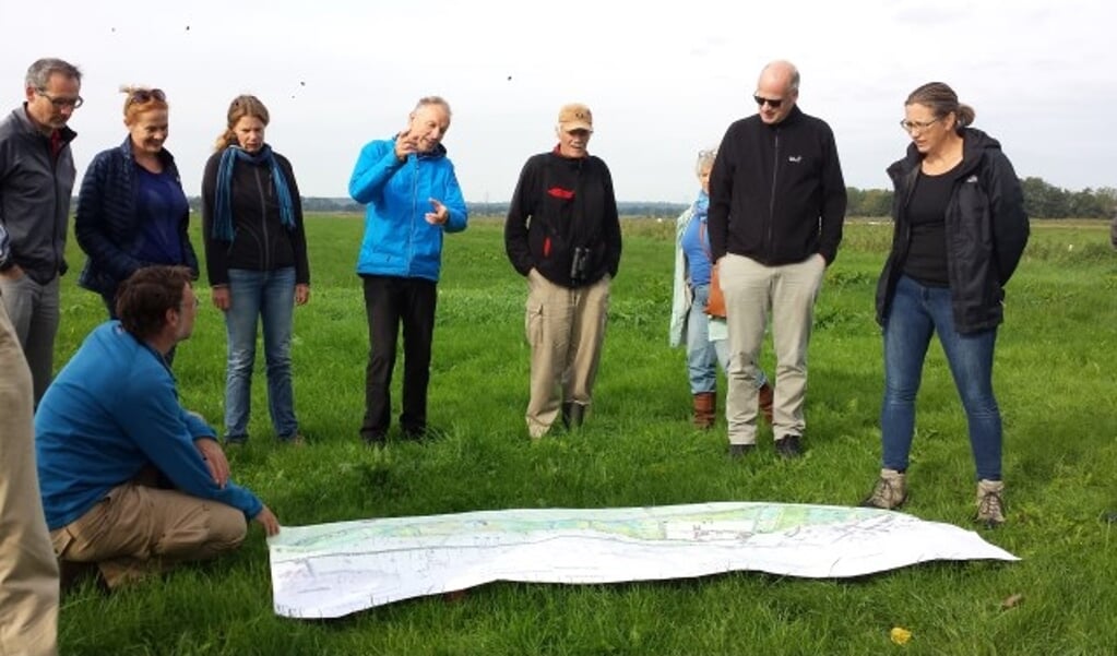 Certificaathouders krijgen uitleg van Rob Janmaat (in blauwe jas) over de plannen voor nieuwe natuur tijdens de excursie door het Binnenveld.