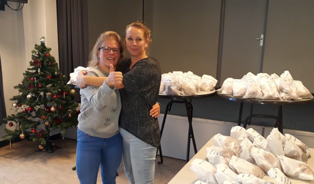Sandy Schalk en Mariska Jansen tussen de oliebollen.