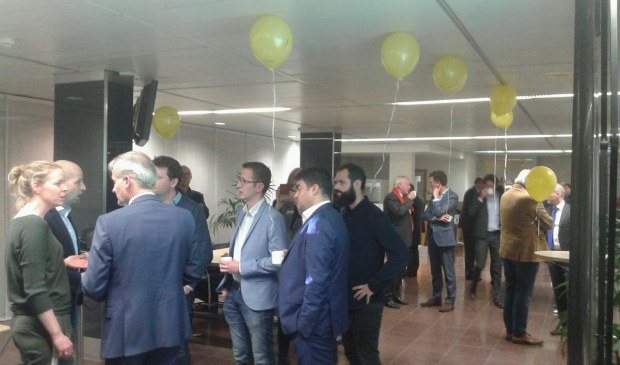 Tegenstanders van de rondweg (met gele ballonnen) spreken politici in de wandelgangen.