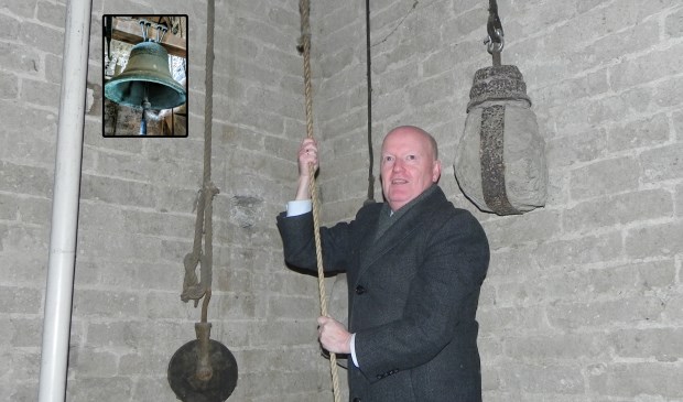 Burgemeester van Bennekom laat met krachtige halen aan het touw de antieke kleine klok van de St. Stevenskerk klinken.