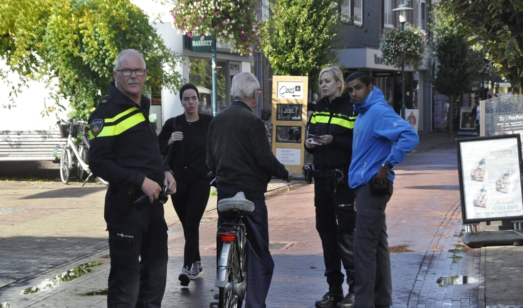 Wijkagent Dick van Hunnik (links) hield samen met collega's een actie tegen fietsen in het voetgangersgebied.