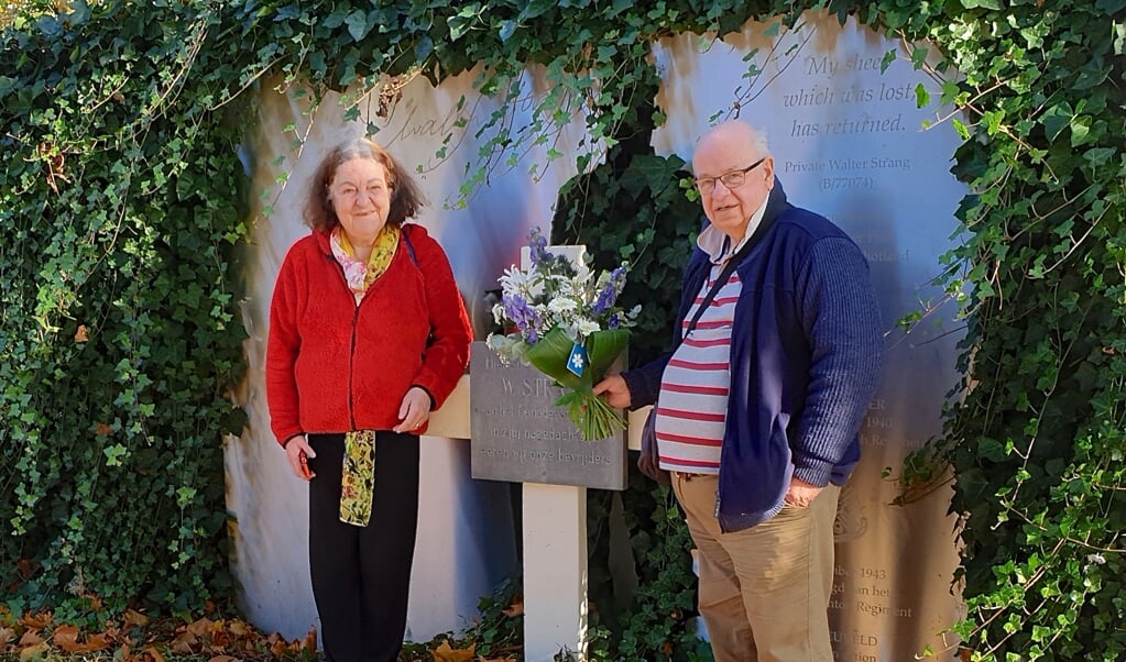 Ronnie en Denise Strang leggen een wit-blauw boeket bloemen bij het monument van neef Walter Strang.