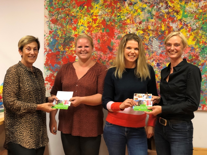 Oudercommissieleden van Stichting Peuterspeelzalen Hardinxveld-Giessendam ontvangen de eerste folder Spelen met een plus