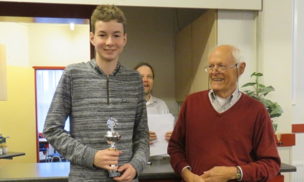 De boomlange Thijs van Dam ontving van jeugdleider Jan Wouters zijn prijs. Op de achtergrond kijkt medeorganisator Hotze Tette Hofstra toe.
