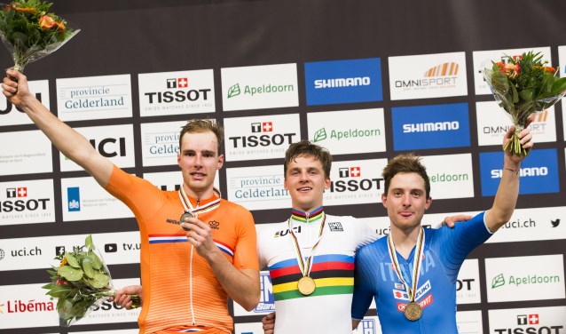 Winnaar Szymon Sajnok (POL) op het podium van het omnium te midden van Jan Willen van Schip (links) (tweede) en Simone Consonni (ITA)