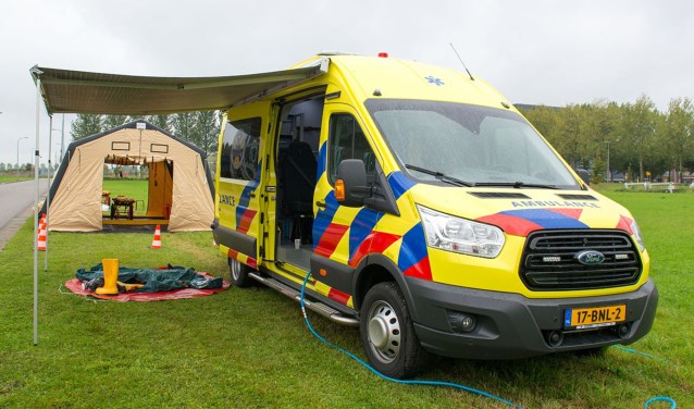 De HART-ambulance met op de achtergrond de tent waarin gewonden ontsmet en behandeld worden.