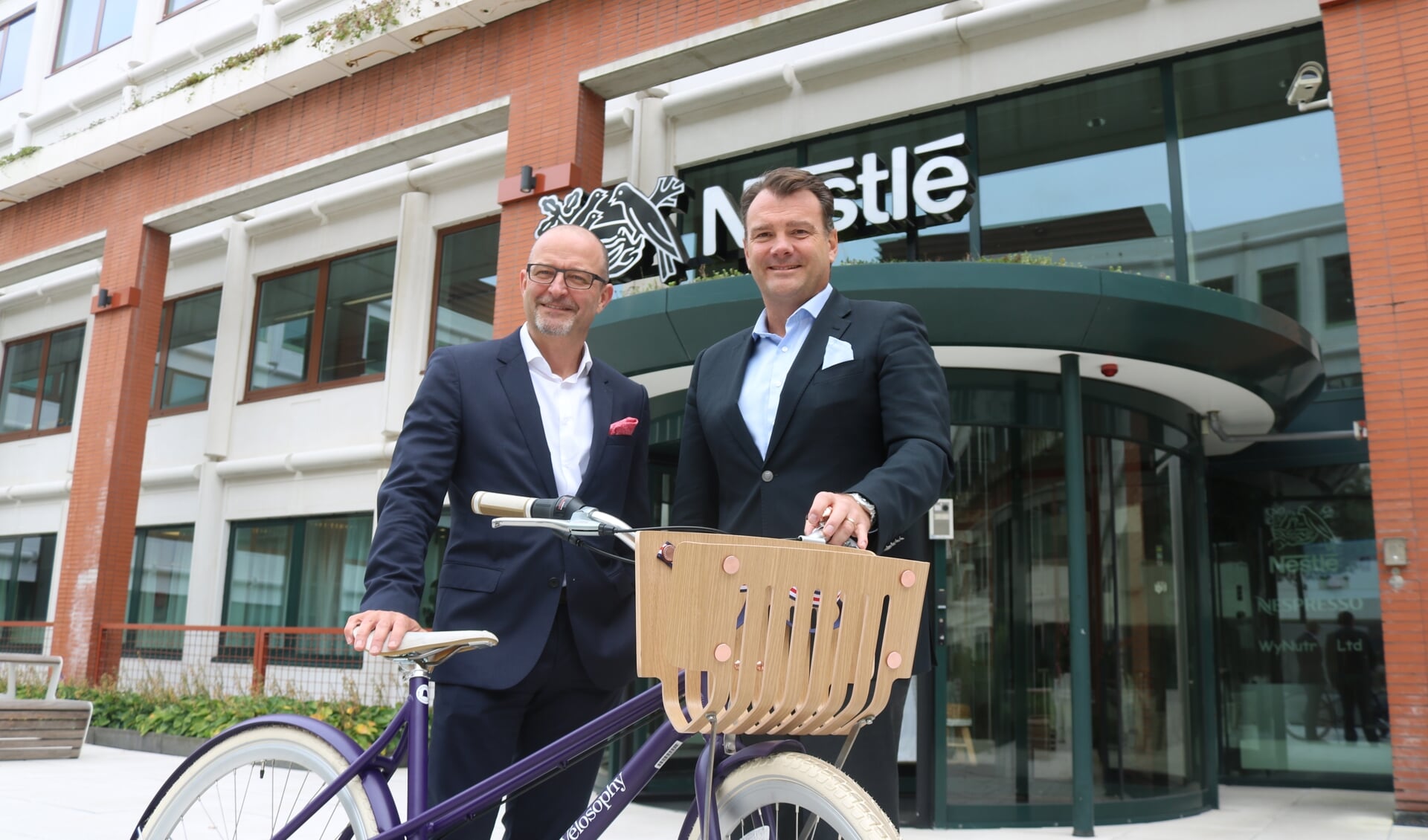 CEO Nestlé Nederland Fabrice Favero (rechts) met Daniel Schneider, BEO Nespresso. en een fiets gemaakt van koffiecapsules.


