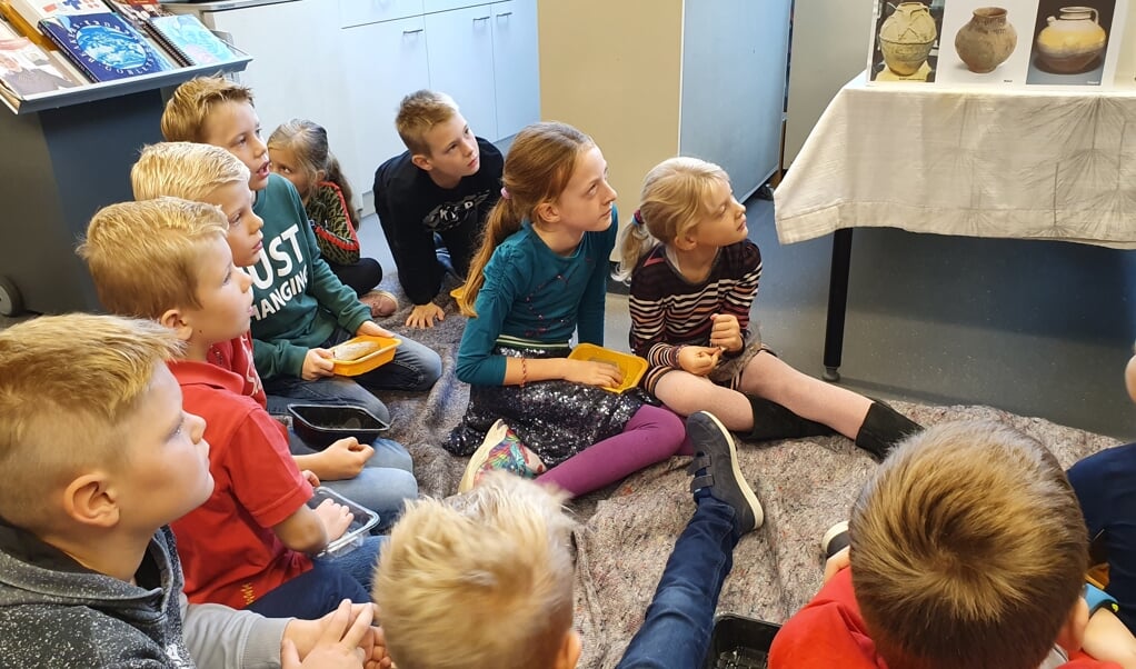 Kinderen luisteren geboeid naar verhalen over de Romeinse tijd