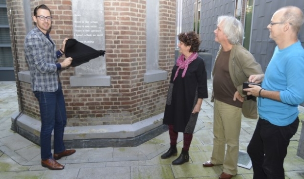 Wethouder Lochtenberg onthult het nieuwe rijm. Rechts Daphne Kalff van Gedichten op Muren en Henk Johannes van de Heuvel, vriend van Budding. Hij schreef een boek over hem en bij de presentatie vorig jaar liet hij al doorschemeren dat een gedicht passend zou zijn op de schoorsteen. (Foto´s: Pieter Vane)