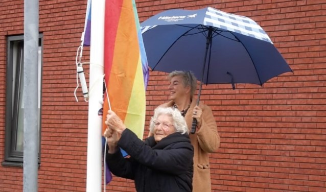 De 101-jarige Beppie van der Werf hijst de regenboogvlag.