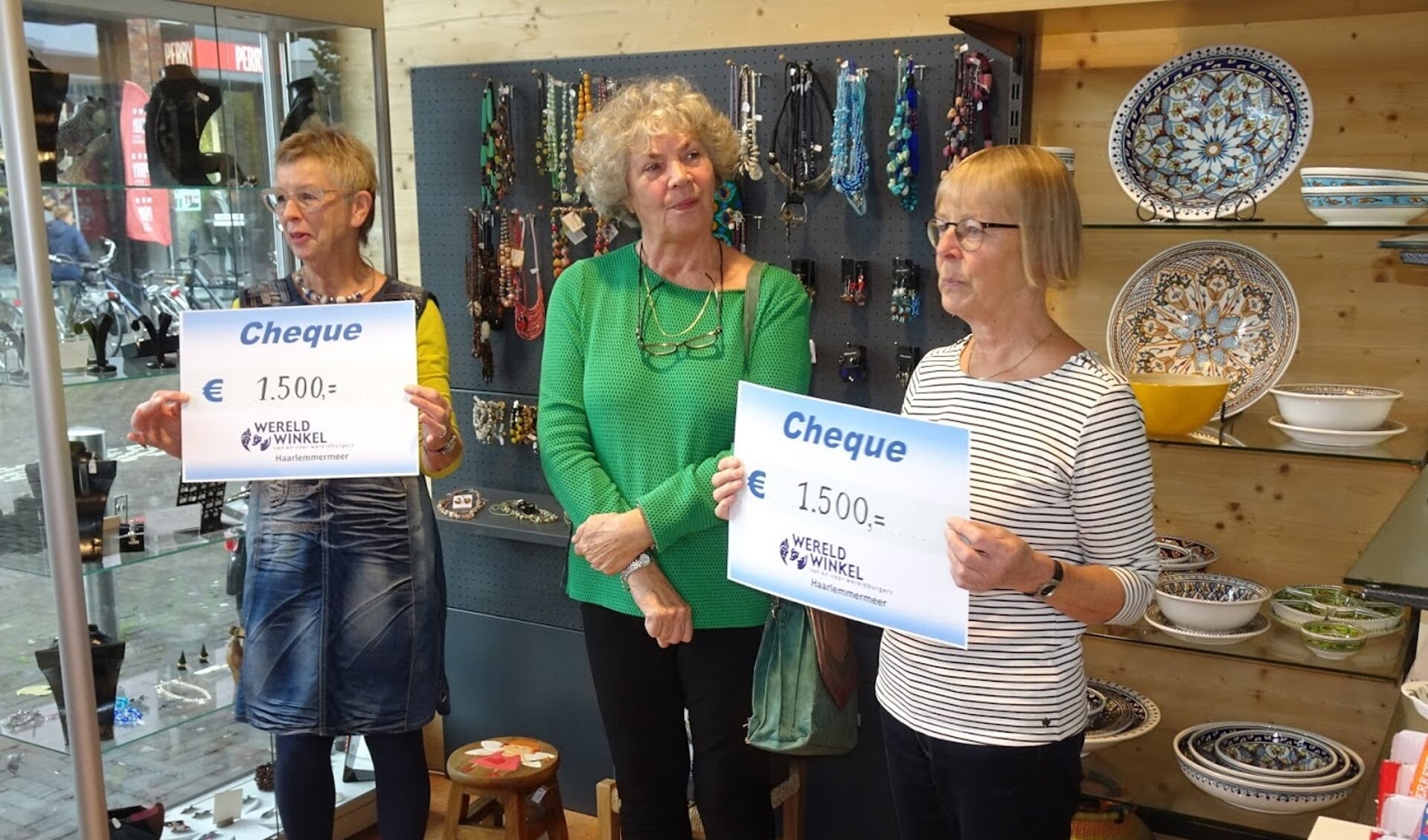 Marina Visschedijk en Klara Dam en Rhodé Tanja met hun cheques in de Hoofddorpse wereldwinkel. 