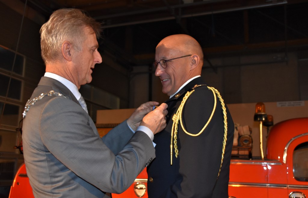 Burgemeester Rob Metz spelt de onderscheiding op bij Harrie Tolboom.
