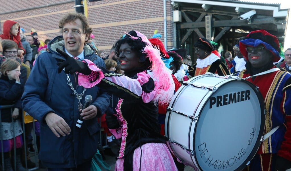 Een Zwarte Piet wijst burgemeester René Verhulst de weg naar Sinterklaas tijdens de intocht van vorig jaar. 