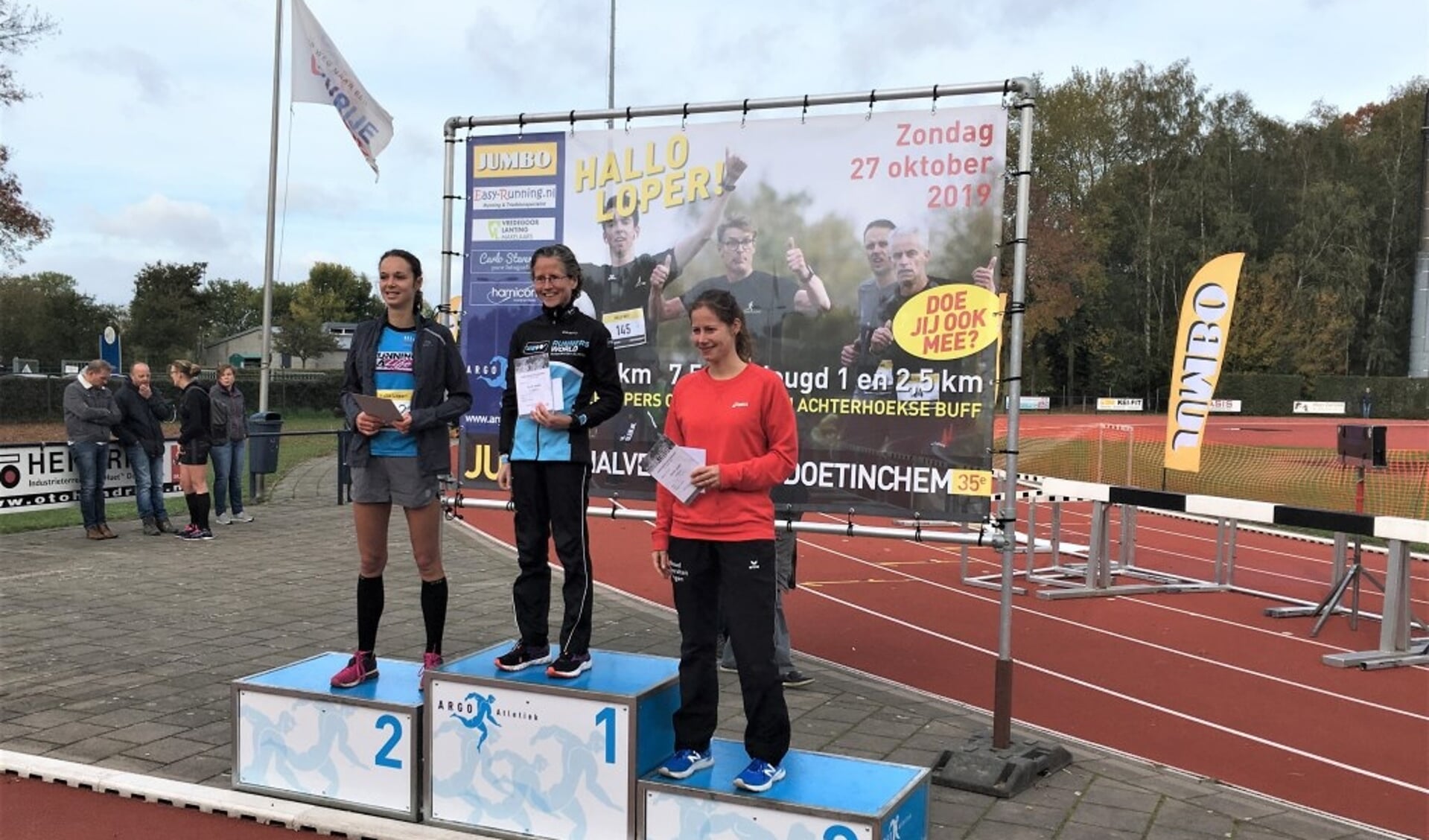 Mireille Baart staat op de hoogste trede van het podium nadat zij de Halve Marathon van Doetinchem had gewonnen.