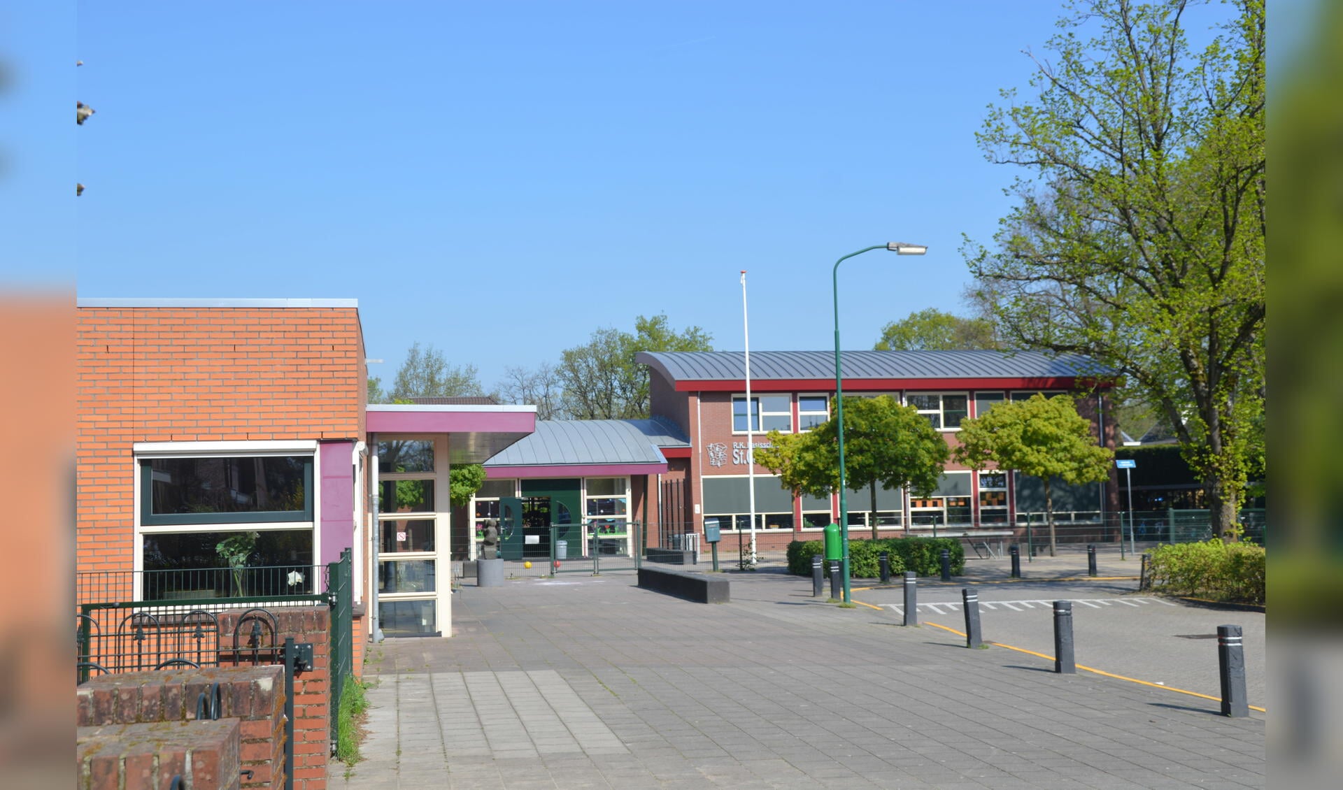 Het 'dorpshuis' (links) grenst aan het schoolplein van de Carolusschool.