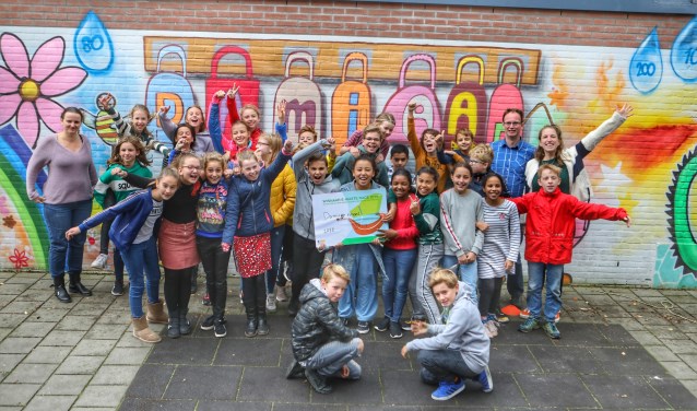 De leerlingen van de Damiaanschool met de cheque. Links recyclingcoach Sanne van RMN.