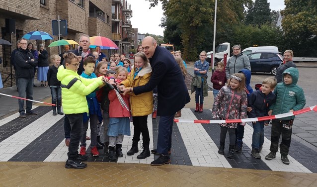 Samen met kinderen van Het Sterrenbos en De Regenboog knipt wethouder Gerrit Boonzaaijer het lint door.