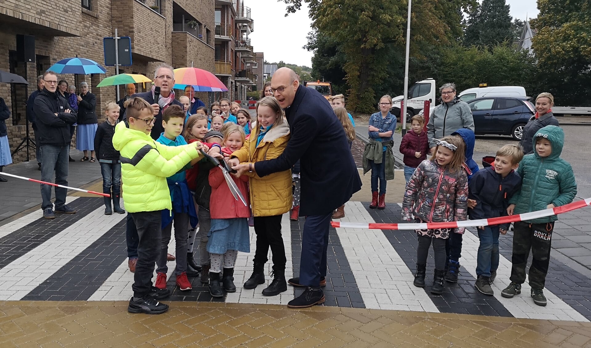 Samen met kinderen van Het Sterrenbos en De Regenboog knipt wethouder Gerrit Boonzaaijer het lint door.