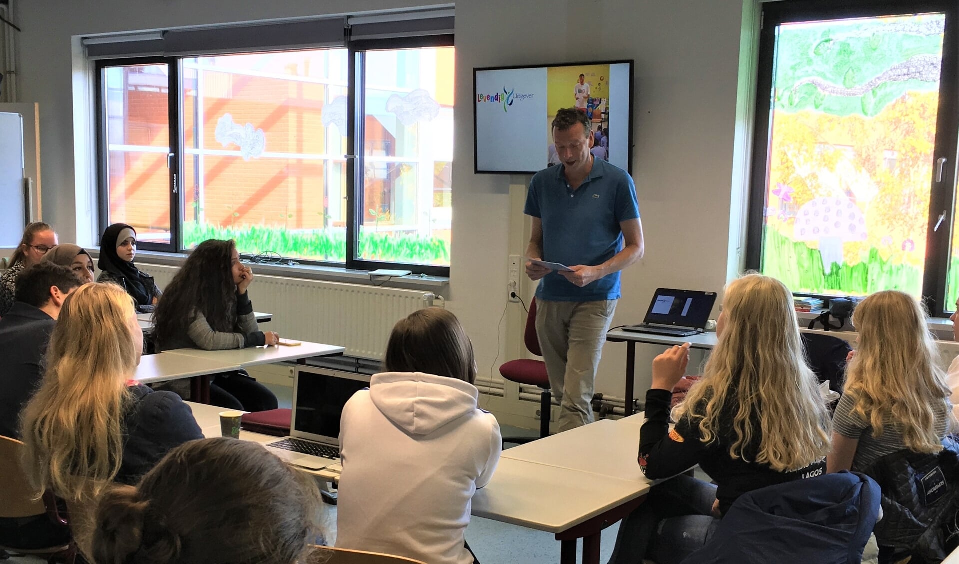 Jeroen Hoogerwerf leest de studenten Onderwijsassistenten voor uit eigen werk.
