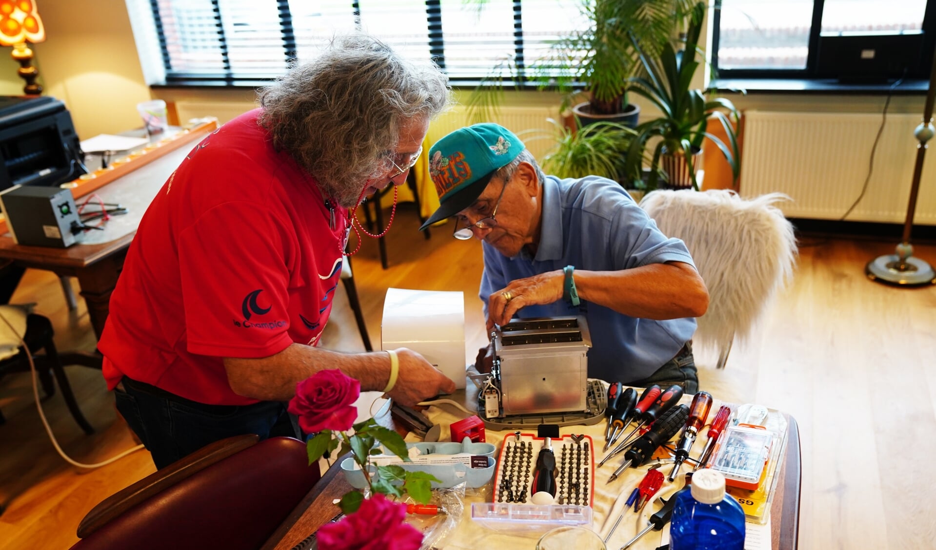 De vrijwilligers helpen elkaar regelmatig bij het maken van een apparaat. 