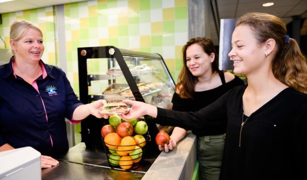 Claudia de Bleije (links) overhandigt een gezond broodje aan een leerling.