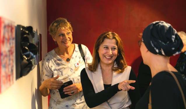 Wethouder Koser Kaya (midden) in gesprek met kunstenaars van De Ploegh tijdens de opening van '25x25x25'.