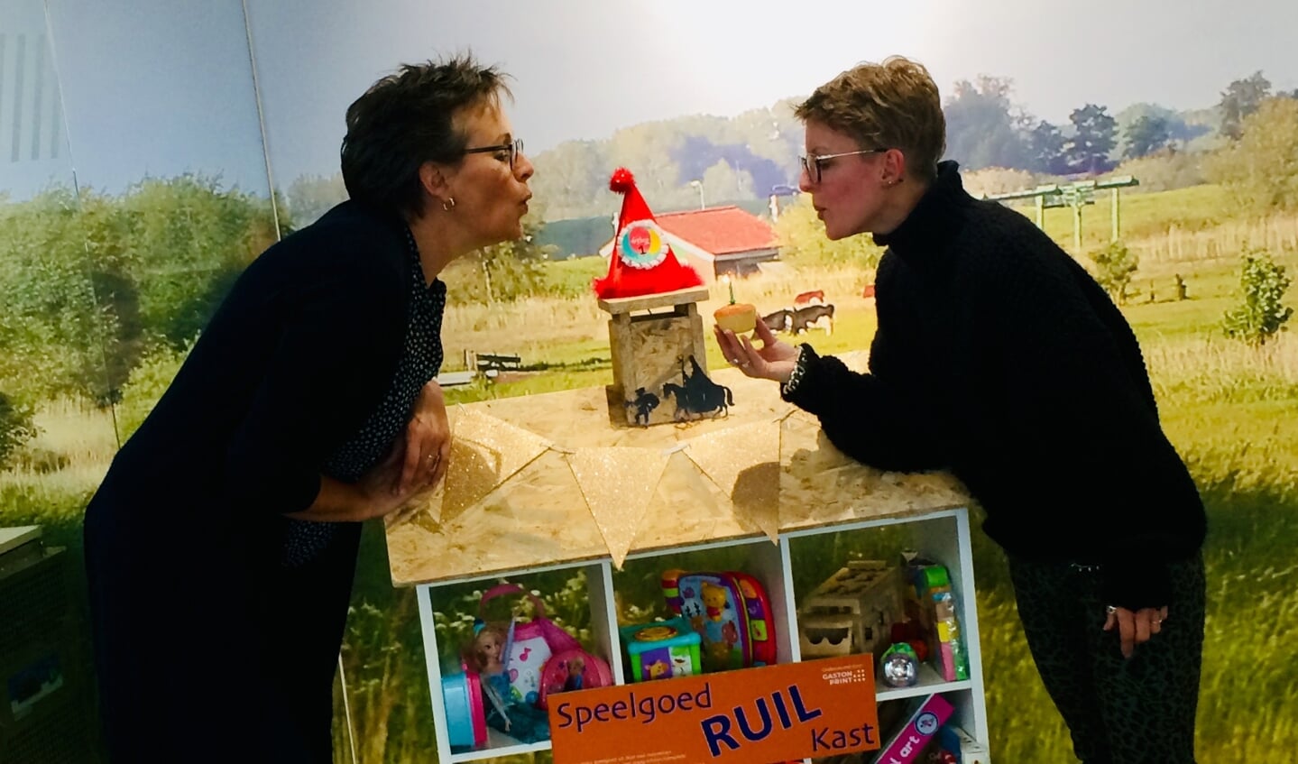 Moniek en Petra, van de bibliotheek blazen samen een kaarsje uit ter gelegenheid van de 1e verjaardag van de speelgoedRUILkast.