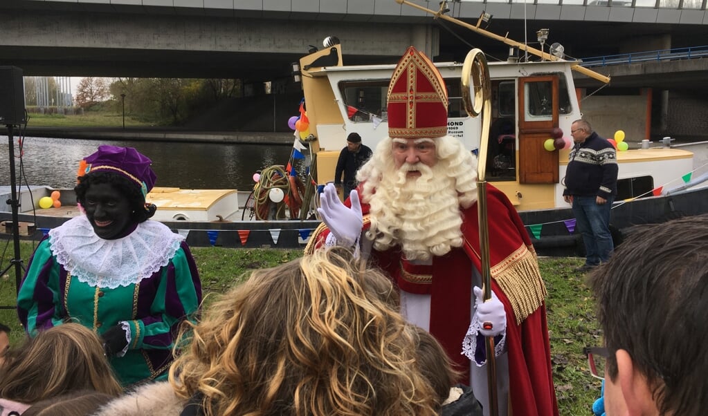 Sinterklaas heeft zojuist voet aan wal gezet bij de Duivendrechtsekade en schudt heel veel handen