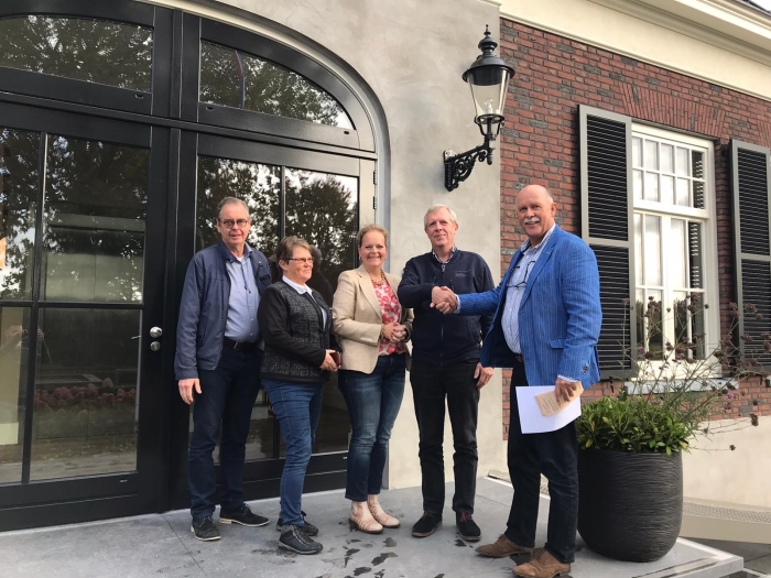 Henk van den Oever van de Stichting Idee in Uitvoering feliciteert Jan Schut van de Stichting Vakantieweek Ede.