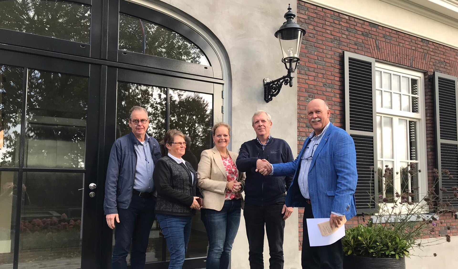Henk van den Oever van de Stichting Idee in Uitvoering feliciteert Jan Schut van de Stichting Vakantieweek Ede.