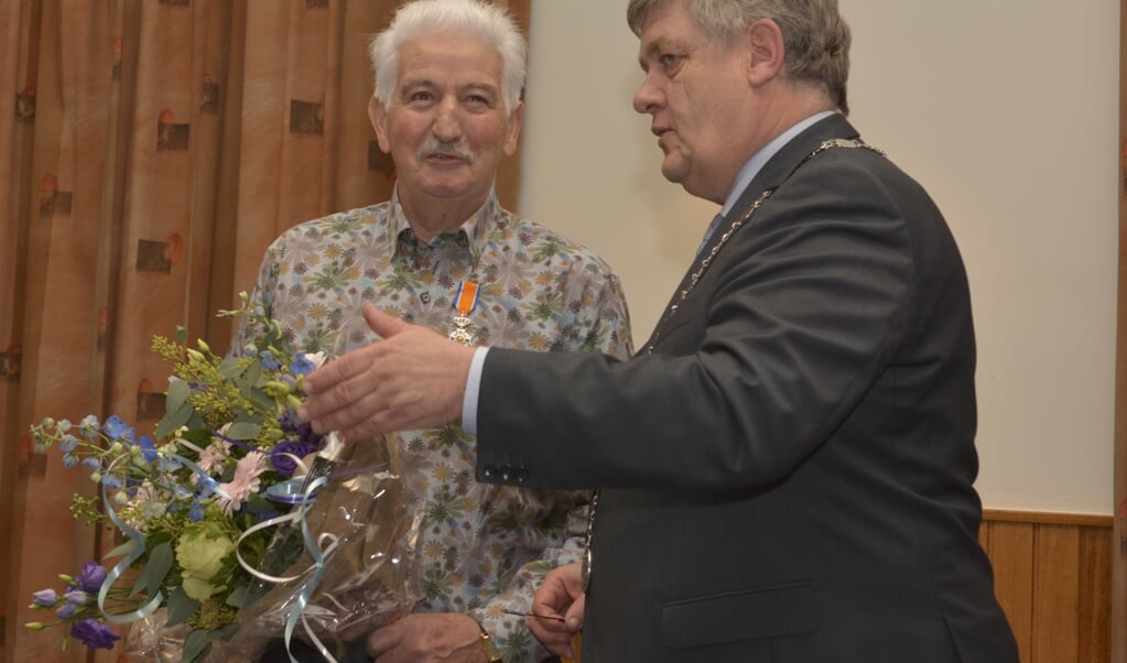 Harmen Teunissen krijgt zijn Koninklijke onderscheiding uitgereikt door burgemeester Lambooij