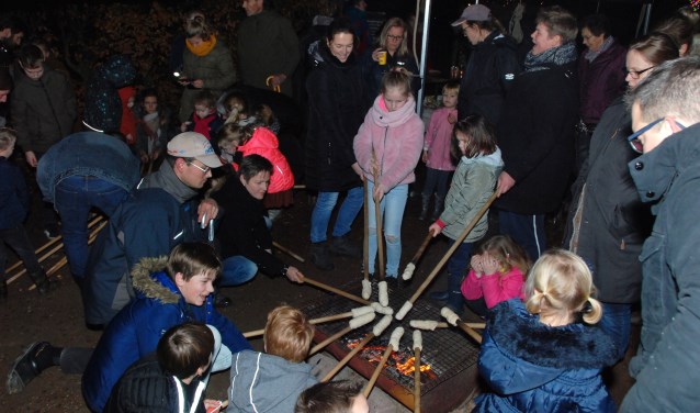 Onder leiding van Scouting bakken jongeren broodjes.