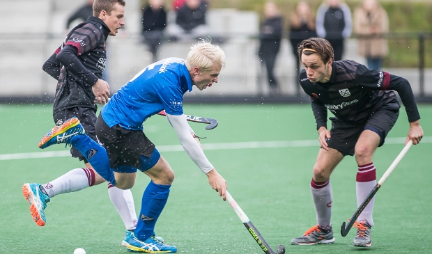 <p>Luke Dommershuijzen (in het blauwe MHC Ede shirt) maakt een mooie periode door. Maar mist competitiehockey met Amsterdam ook.</p>