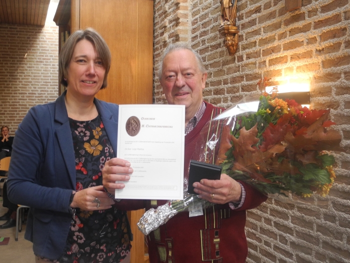 Mevr. Slaghekke-van Wijk overhandigt Catharinapenning en oorkonde aan de heer Martina.