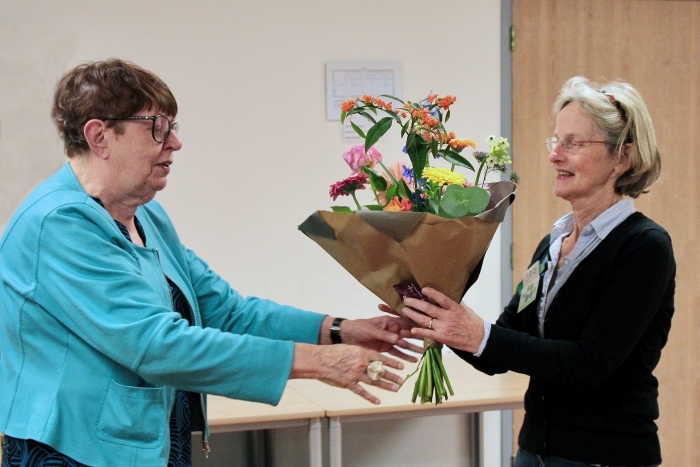 Voorzitter Rozalien van de Kletesteeg (links) verwelkomt het 300ste lid met een boeket bloemen.