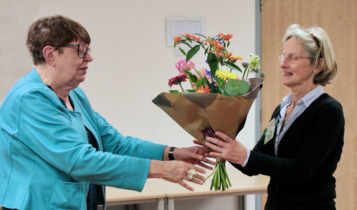 Voorzitter Rozalien van de Kletesteeg (links) verwelkomt het 300ste lid met een boeket bloemen.