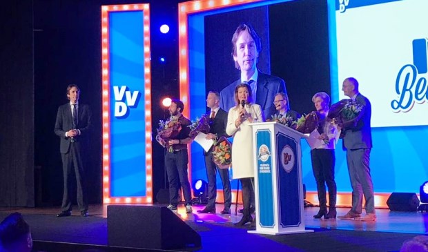 De Amstelveense wethouder Herbert Raat (links en op het wandscherm) bij de uitreiking van de oorkonde tijdens het VVD-congres.