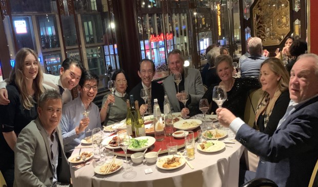 De familie Pang (links aan tafel) bij het benefietdiner in Amsterdam.