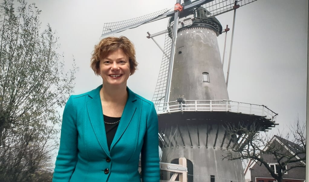 Wethouder Erika Spil bij een poster van de molen van Werkhoven op het gemeentehuis