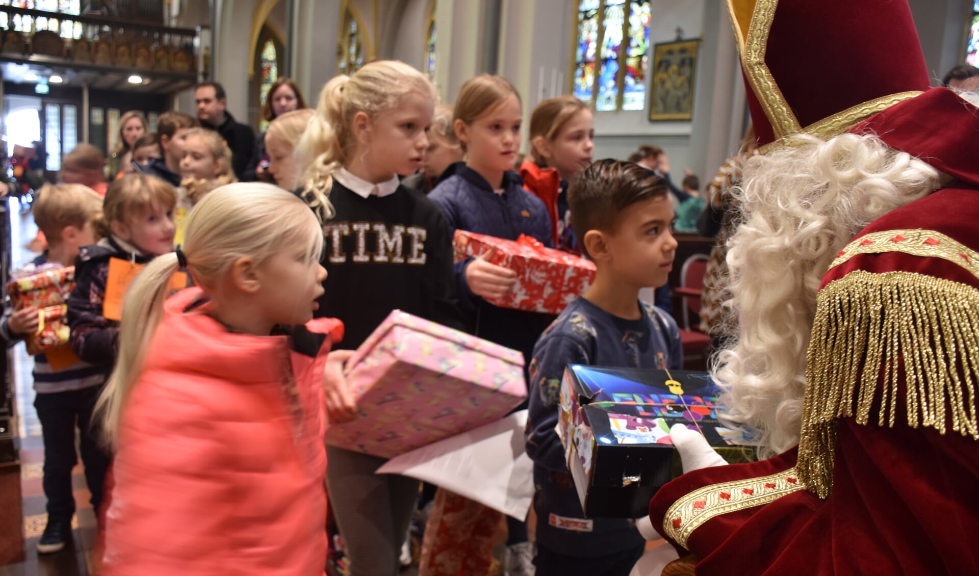 Kinderen bieden de Sint hun schoendoos aan