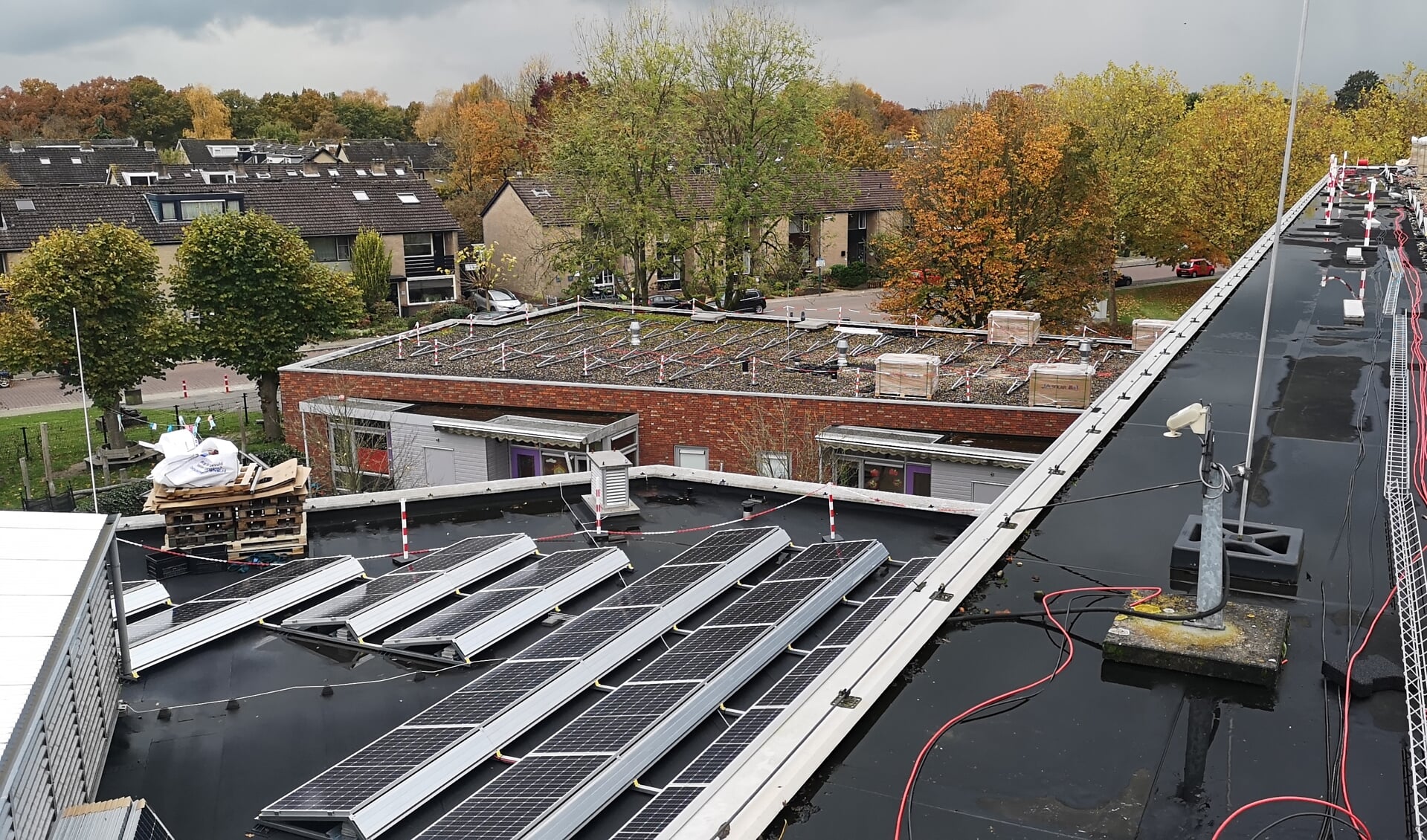 De installatie van de zevenhonderddrie zonnepanelen op de daken van De Binder vordert vlot.
