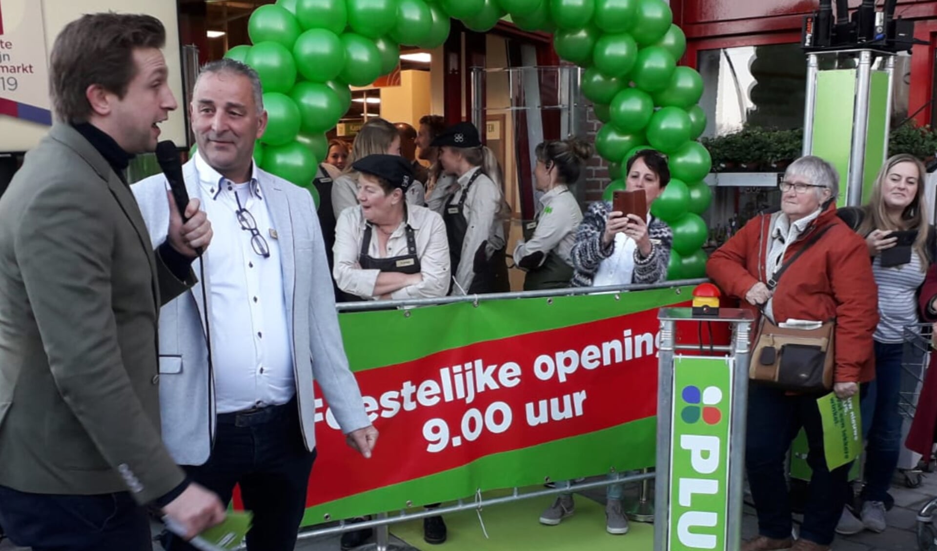 Supermarktmanager Geurt Schut (tweede van links) en zijn team wachten met spanning op het moment waarop de  winkel wordt geopend.