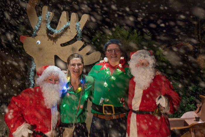 Feestgangers werden opgewacht door een fotograaf, twee kerstmannen en een wel heel plaatselijke sneeuwbui.