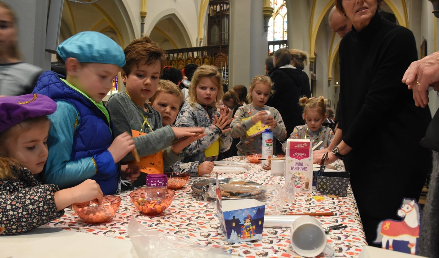 Kinderen versieren een speculaaspop tijdens het spelletjescircuit