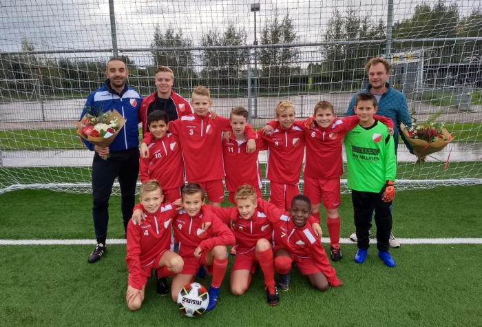 Team JO11-2 poseert in de nieuwe trainingspakken samen met de heren Van Milligen en de Vries