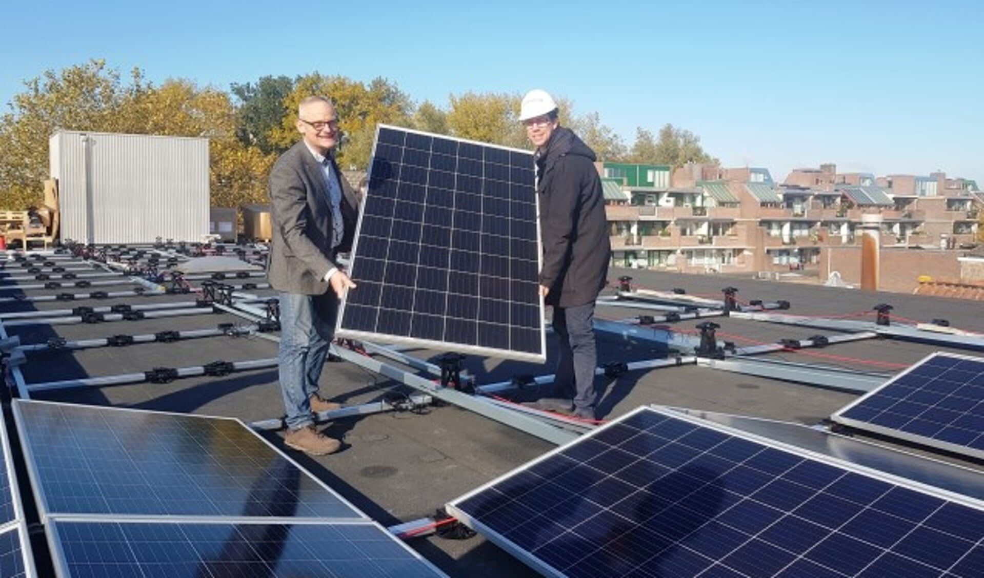 Ruud van Doorn van HEMA Wageningen en wethouder Peter de Haan met 1 van de 260 zonnepanelen. (foto: Kees Stap)