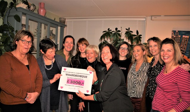 Carola van Staaveren (2e van links) krijgt de cheque aangeboden.