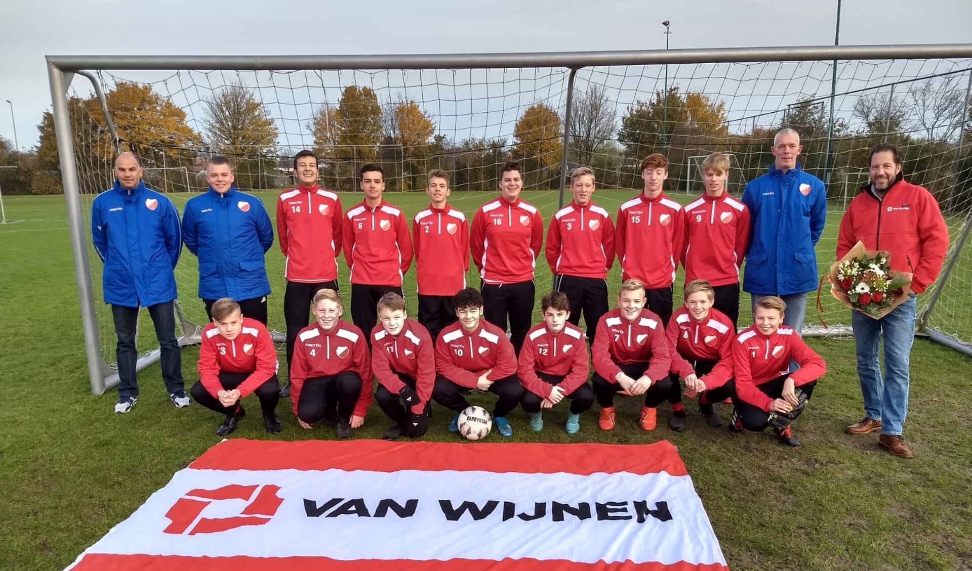 Spelers en trainers van de JO17-2 poseren samen met dhr. van MImpen namens sponsor Van Wijnen in hun nieuwe trainingspakken